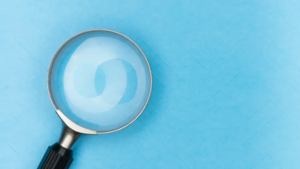 A magnifying glass on a white table, a symbol of searching for the right words