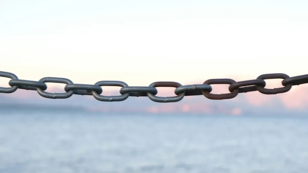 A brown metal chain on a white background, links connected one to another